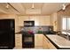 Galley kitchen with black appliances and light wood cabinets at 4015 N 78Th St # 141, Scottsdale, AZ 85251