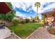 Landscaped backyard with grassy area and covered patio at 4043 W Saguaro Park Ln, Glendale, AZ 85310