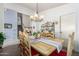 Bright dining room features a wood table with seating for six and a lovely chandelier at 4043 W Saguaro Park Ln, Glendale, AZ 85310