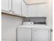 Laundry room with washer and dryer, and upper cabinets at 4043 W Saguaro Park Ln, Glendale, AZ 85310