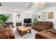 Cozy living room with brown leather sofas, a wood coffee table, and a fireplace at 4043 W Saguaro Park Ln, Glendale, AZ 85310