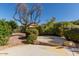 Landscaped backyard with fire pit and mature trees at 42899 W Whimsical Dr, Maricopa, AZ 85138