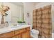 Clean bathroom with wood vanity and patterned shower curtain at 42899 W Whimsical Dr, Maricopa, AZ 85138