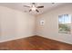 Spacious bedroom with hardwood floors and ceiling fan at 42899 W Whimsical Dr, Maricopa, AZ 85138