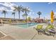 Refreshing community pool surrounded by palm trees and lounge chairs at 4750 N Central Ave # N16, Phoenix, AZ 85012