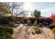 Landscaped backyard with brick patio, fire pit, and charming stone structure at 533 W Lewis Ave, Phoenix, AZ 85003