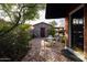 Brick patio with seating area, stone shed, lush landscaping, and pergola at 533 W Lewis Ave, Phoenix, AZ 85003