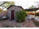 Charming stone shed with red door in a landscaped backyard setting at 533 W Lewis Ave, Phoenix, AZ 85003