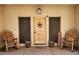 Inviting porch featuring rocking chairs and charming decor surrounding the entryway with star decorated door at 5713 W Sun Dance Dr, Queen Creek, AZ 85144