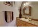 Bathroom with granite countertop, wooden cabinets, and decorative mirror at 5713 W Sun Dance Dr, San Tan Valley, AZ 85144