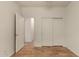 Bright bedroom with wood floors and double doors to closet at 5810 W Puget Ave, Glendale, AZ 85302