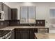 Modern kitchen featuring dark cabinetry, granite countertops, and stainless steel appliances at 5810 W Puget Ave, Glendale, AZ 85302