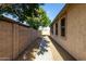 Side yard with concrete pathway, block wall, and mature shade tree at 5810 W Puget Ave, Glendale, AZ 85302