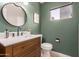 Updated bathroom with modern vanity and green painted walls at 6046 W Carol Ann Way, Glendale, AZ 85306