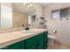 Bathroom boasts a modern vanity with green cabinetry and a tile shower at 6046 W Carol Ann Way, Glendale, AZ 85306