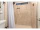 Shower stall with beige tile and built-in shelving at 6046 W Carol Ann Way, Glendale, AZ 85306