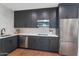 Modern kitchen with dark cabinetry, stainless steel appliances, and marble countertops at 6916 E 2Nd St, Scottsdale, AZ 85251