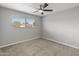 Bright bedroom with ceiling fan, carpet, and large window at 7443 E Taylor St, Scottsdale, AZ 85257