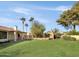 Backyard oasis featuring a brick fireplace and expansive grassy area at 7550 E Ironwood Ct, Scottsdale, AZ 85258