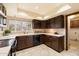 Kitchen with dark wood cabinets, and a view of laundry room at 7550 E Ironwood Ct, Scottsdale, AZ 85258