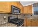 Stainless steel microwave and gas range in a kitchen with granite countertops at 7606 E Globemallow Ln, Gold Canyon, AZ 85118