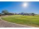 Green grassy area with paved pathway and houses visible in distance at 86 E Iloca Ln, Queen Creek, AZ 85140