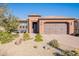 Single-story home with two-car garage, desert landscaping, and outdoor seating at 86 E Iloca Ln, Queen Creek, AZ 85140