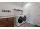 Bright laundry room with washer, dryer, and ample storage at 86 E Iloca Ln, Queen Creek, AZ 85140