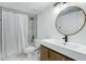 Clean bathroom with a round mirror and wood vanity at 8740 W Bloomfield Rd, Peoria, AZ 85381