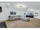 Open Gathering room with grey sectional sofa and view to kitchen and stairs at 8740 W Bloomfield Rd, Peoria, AZ 85381