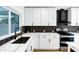 Modern kitchen with white cabinets, a black hexagon backsplash and a farmhouse sink at 8740 W Bloomfield Rd, Peoria, AZ 85381