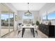 Dining room with modern chandelier, large sliding glass door, and a large window for ample natural light at 10053 E Seismic Ave, Mesa, AZ 85212