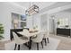 Bright dining room featuring a modern light fixture, six chairs, and a window providing natural light at 10053 E Seismic Ave, Mesa, AZ 85212