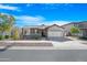 House exterior showcasing a charming curb appeal with landscaping and a two-car garage at 10053 E Seismic Ave, Mesa, AZ 85212