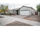 Front view of a charming house with a white garage door and landscaped yard at 10053 E Seismic Ave, Mesa, AZ 85212