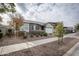 House with gray brick and a landscaped front yard, including bushes and trees at 10053 E Seismic Ave, Mesa, AZ 85212