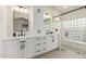 Modern bathroom with double vanity, large shower, and glass block window at 10828 E Flintlock Dr, Sun Lakes, AZ 85248