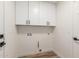 Bright laundry room with white cabinets and vinyl flooring at 10828 E Flintlock Dr, Sun Lakes, AZ 85248