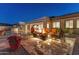 Patio with fire pit and comfortable seating area at night at 11842 W Creosote Dr, Peoria, AZ 85383