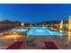 Large rectangular pool and spa with night lighting and mountain views at 11842 W Creosote Dr, Peoria, AZ 85383