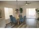 Charming dining area with a glass-top table and four blue chairs, near sliding doors at 12221 N 122 Dr, El Mirage, AZ 85335