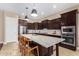 Stylish kitchen featuring dark cabinetry, a large island with seating, and high-end appliances at 1536 W Blaylock Dr, Phoenix, AZ 85085