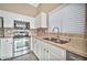 White kitchen with stainless steel appliances and double sink at 15653 W Monterey Way, Goodyear, AZ 85395