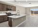 Modern kitchen with island, stainless steel appliances, and tile floor at 1587 S 239Th Dr, Buckeye, AZ 85326