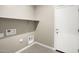 Laundry room with built-in shelving and hookups for washer/dryer at 1587 S 239Th Dr, Buckeye, AZ 85326