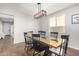 Elegant dining room features a rustic wooden table and black chairs, near entryway at 1649 N 212Th Dr, Buckeye, AZ 85396