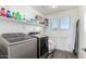 Bright laundry room with washer, dryer, and ample shelving at 1649 N 212Th Dr, Buckeye, AZ 85396