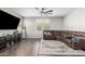 Living room with sectional sofa, large TV, and ceiling fan at 1649 N 212Th Dr, Buckeye, AZ 85396