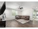 Living room with sectional sofa, large TV, and ceiling fan at 1649 N 212Th Dr, Buckeye, AZ 85396