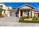 Craftsman style home with stone exterior, gray garage door, and landscaped front yard at 16611 S 9Th St, Phoenix, AZ 85048